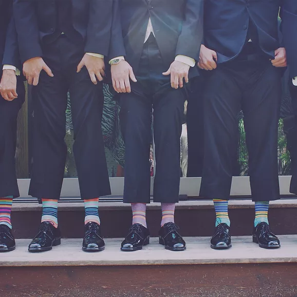 Bottom half of formally dressed men with colorful socks